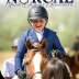 Child patting chestnut pony with huge smile.